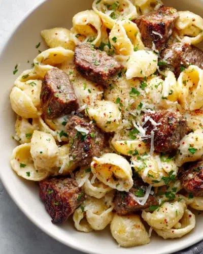 steak bites and shell pasta in garlic butter alfredo sauce recipe card